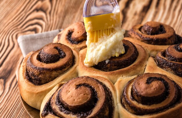 La mano femenina cubre la crema pastelera con un panecillo