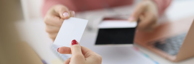 Mano femenina dar tarjeta de visita en blanco visitante socios de cuello blanco intercambio de nombre de empresa y