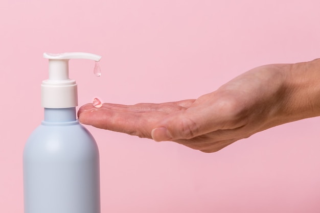 Foto mano femenina con dispensador de botella de desinfectante en gel de alcohol contra el coronavirus