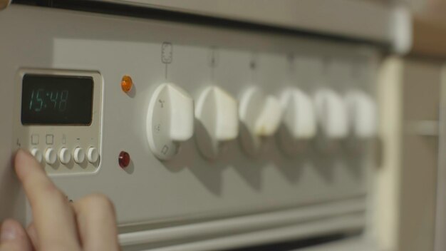 Foto mano femenina encendiendo la estufa de gas de la cocina blanca mujer encendiendo la estufa en la cocina de cerca