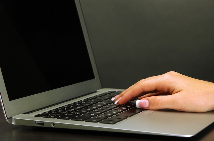 Foto mano femenina escribiendo en laptot de cerca