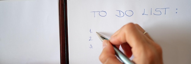 Mano femenina escribiendo una lista de tareas