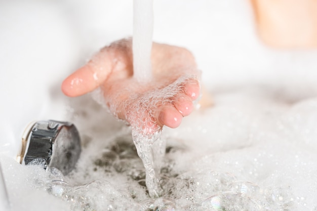 mano femenina en espuma jabonosa