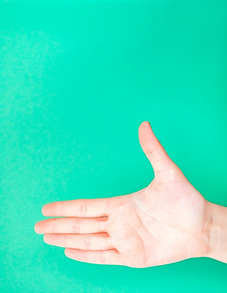 Foto mano femenina en fondo aislado del color verde de la turquesa