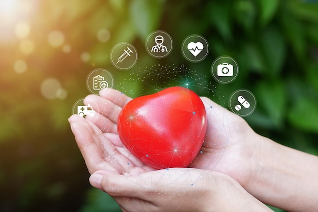 mano femenina con forma de corazón rojo en la mano con icono médico conexión de red moderna virtual