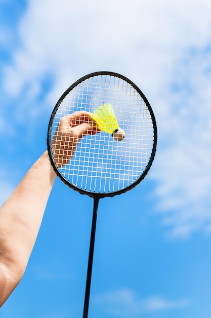 Mano femenina golpea volante por raqueta de bádminton