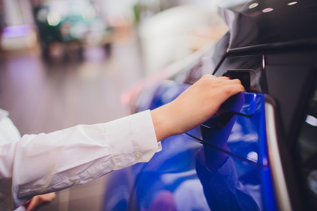 Mano femenina para insertar puerta trasera coche abierto. para transporte e imagen automotriz