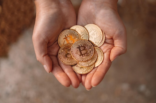 La mano femenina irreconocible muestra una gran cantidad de monedas en efectivo de bitcoin. Endecha plana.