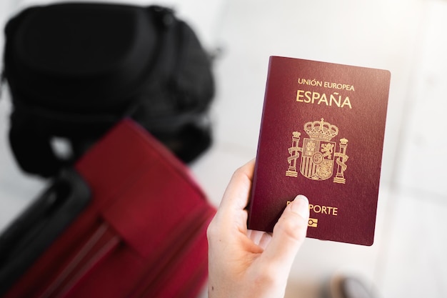 La mano femenina irreconocible del primer sostiene el pasaporte europeo español