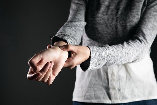 Mano femenina joven que controla el pulso.