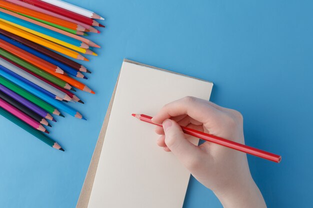 Mano femenina lista para retorcer frase en cuaderno