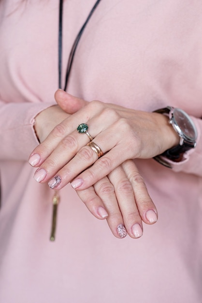 Mano femenina con manicura rosa pastel recién hecha