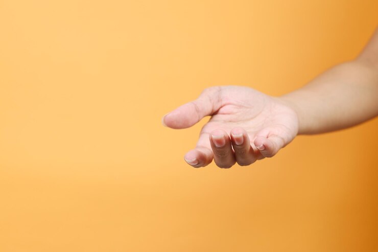 Foto mano femenina manteniendo la palma vacía aislada sobre un fondo amarillo concepto de ofrenda o mendicidad
