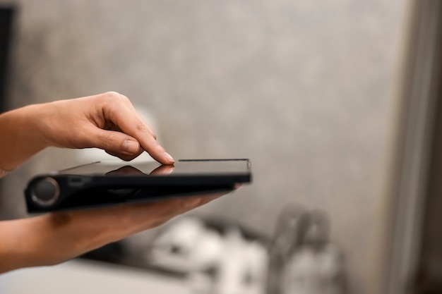 Mano femenina presiona en la pantalla de un primer plano de tableta digital