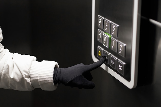 Foto mano femenina presionando los botones del elevador con lenguaje braille