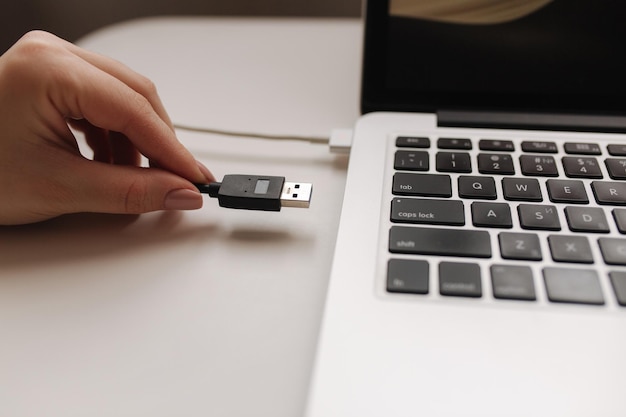 La mano femenina puso el adaptador usb para copiar el archivo por computadora portátil