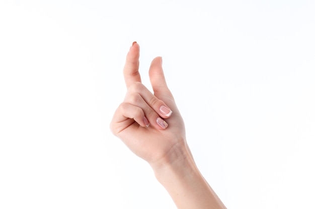 Mano femenina que muestra el gesto con levantado el dedo índice y el pulgar de cerca