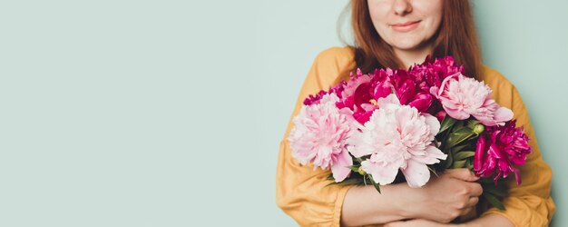 Foto mano femenina que sostiene un hermoso ramo con peonías fragantes