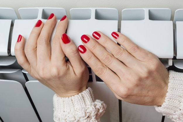 Mano femenina en el radiador