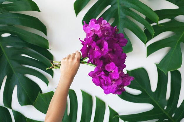 Mano femenina con un ramo de flores de orquídeas