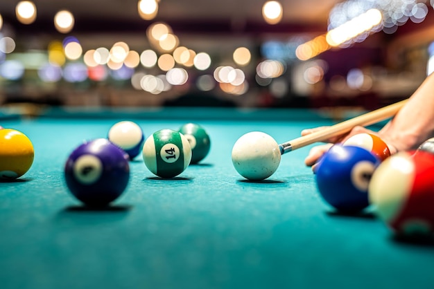 Mano femenina recoge bolas de colores después de jugar al billar y prepara un nuevo juego Concepto de pasar tiempo libre con juegos