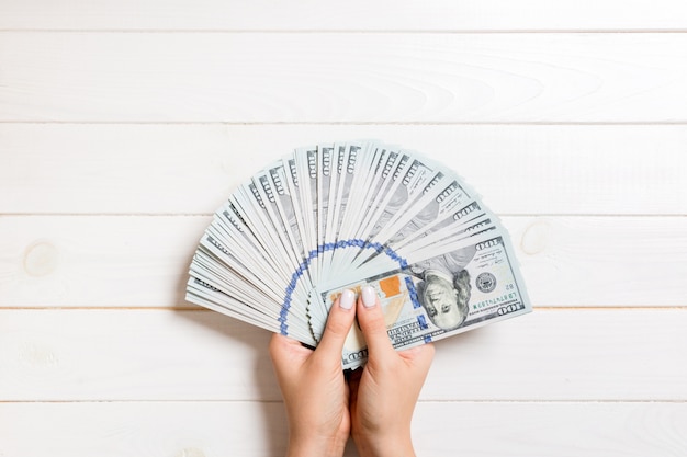 Foto mano femenina sosteniendo un abanico de dinero
