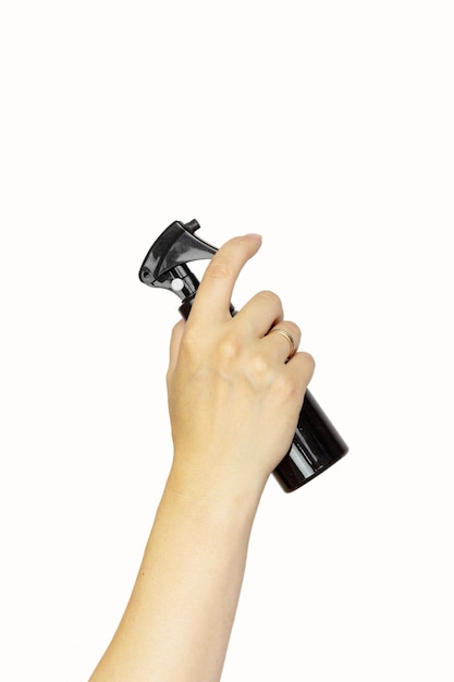 Foto mano femenina sosteniendo accesorios para el cabello rociador de cabello sobre fondo blanco espacio de copia conjunto de herramientas de peluquería sobre fondo blanco