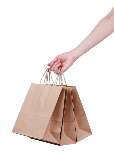 Mano femenina sosteniendo una bolsa de compras de papel aislada en blanco
