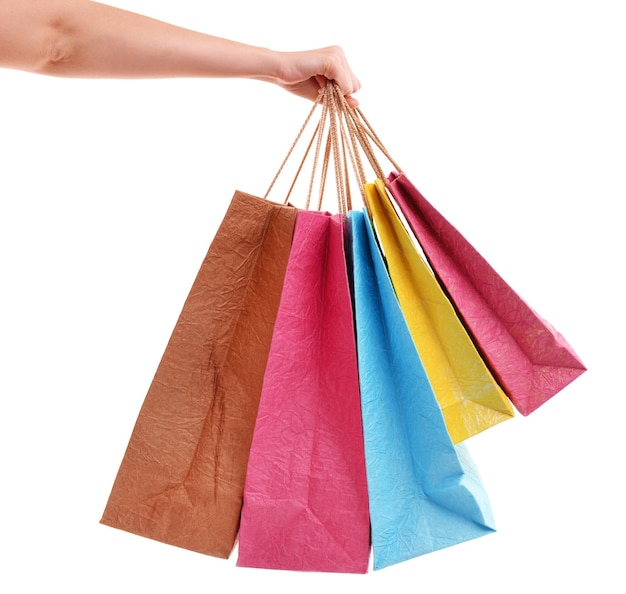 Mano femenina sosteniendo bolsas de papel aisladas en blanco