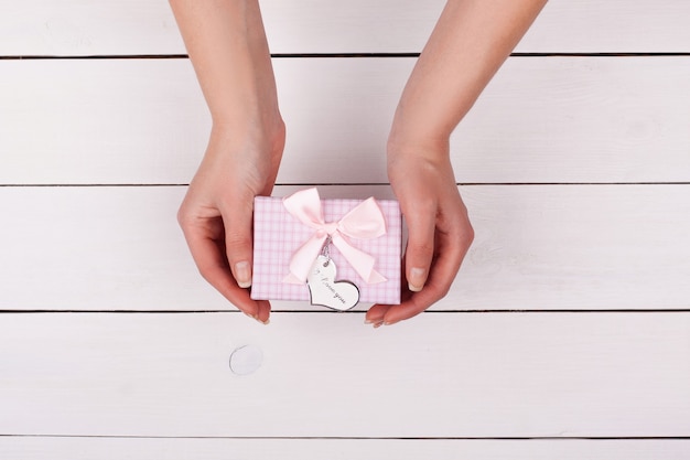 Mano femenina sosteniendo una caja de regalo