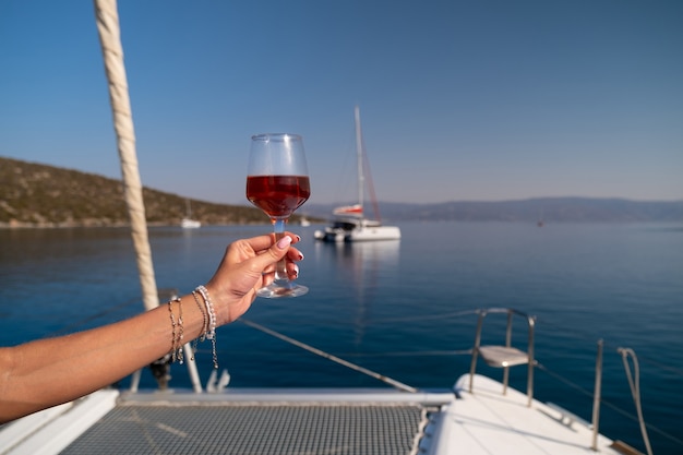 Mano femenina sosteniendo una copa de vino en el fondo del mar