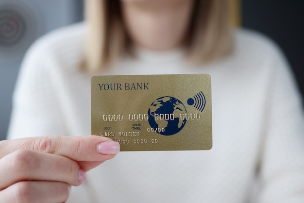 Mano femenina sosteniendo la tarjeta bancaria de crédito closeup