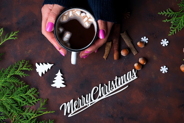 Mano femenina sosteniendo una taza de chocolate caliente