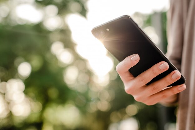 Mano femenina sosteniendo teléfono móvil