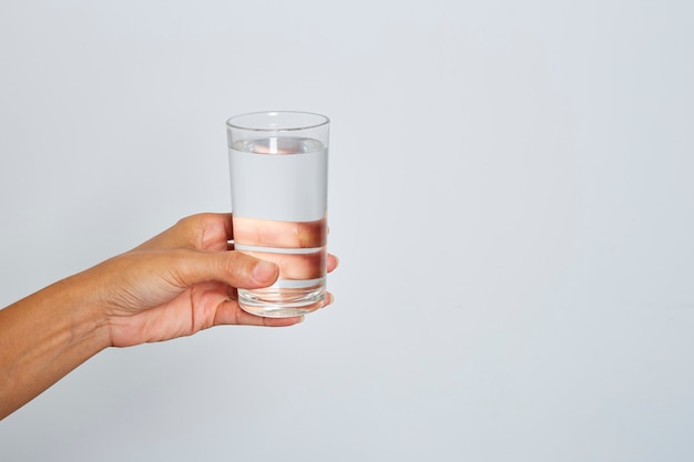 Mano femenina sosteniendo un vaso de agua