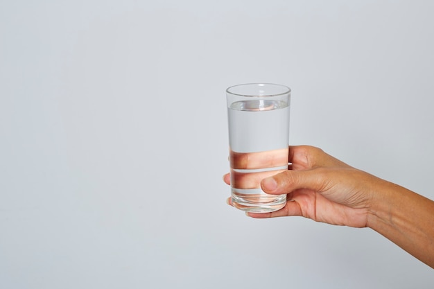 Mano femenina sosteniendo un vaso de agua