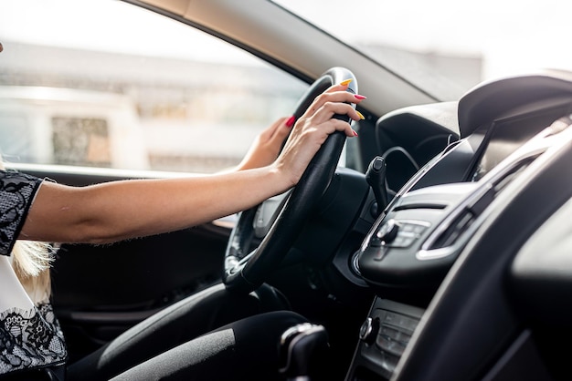 Mano femenina sosteniendo el volante. De cerca. Concepto de viaje