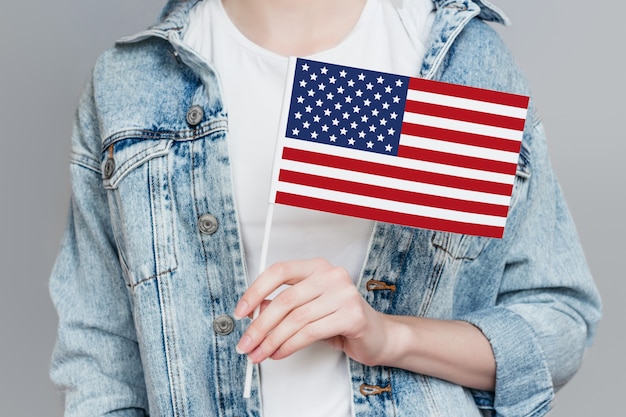 Mano femenina sostiene la bandera de Estados Unidos aislada