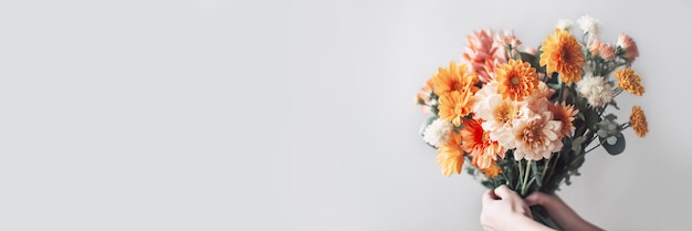 La mano femenina sostiene un hermoso ramo de otoño Banner de entrega de flores Ilustración generativa de IA