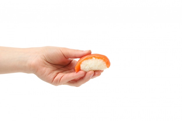 Mano femenina sostiene rollo de sushi, aislado en superficie blanca