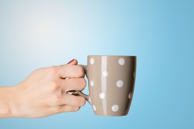 Mano femenina sostiene una taza de té