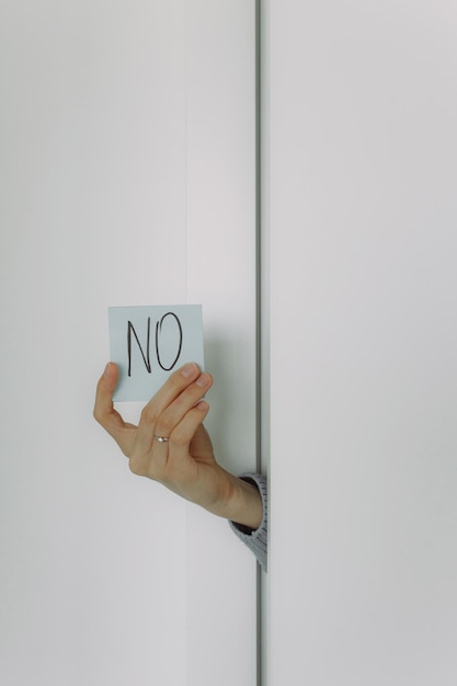 Foto la mano femenina sostiene un trozo de papel con un signo de sí y no, concepto de elección y respuesta a preguntas