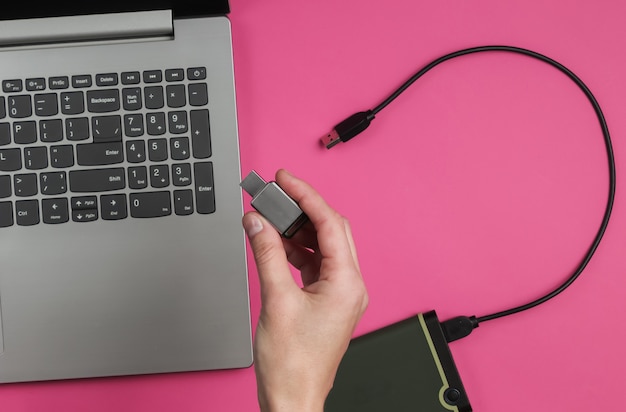 Mano femenina sostiene una unidad flash USB en el papel