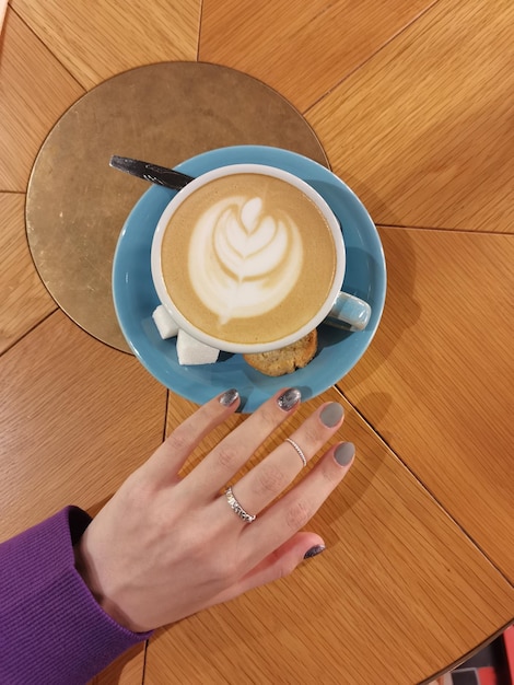 Mano femenina y taza de café en la cafetería creativa san petersburgo cafeterías rusas arco ruso