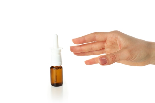 Mano femenina toma botella de spray nasal, aislado sobre fondo blanco.