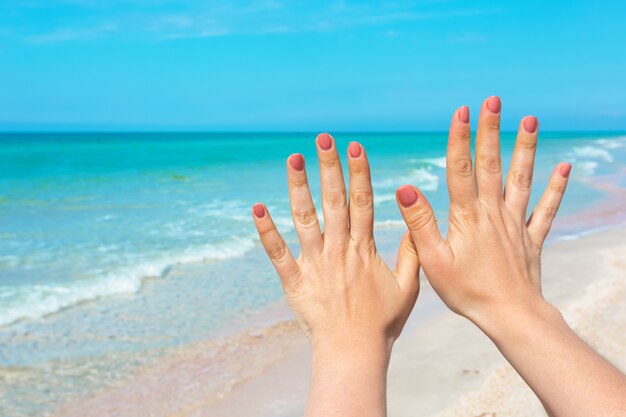 Mano firme sobre mar azul y cielo, viajes de verano, vacaciones