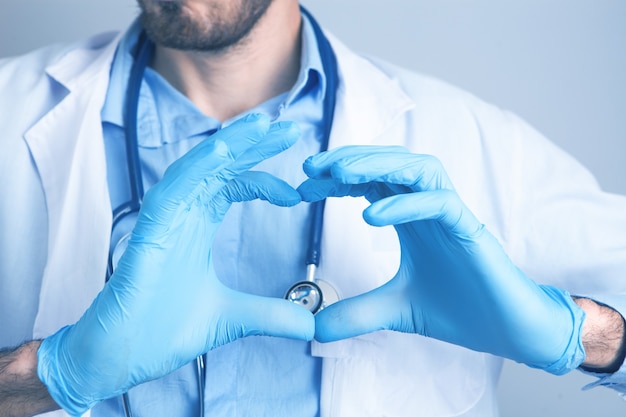 Mano en forma de corazón en guantes médicos