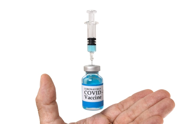Una mano con un frasco de vidrio levitante etiquetado como vacuna contra el coronavirus COVID19