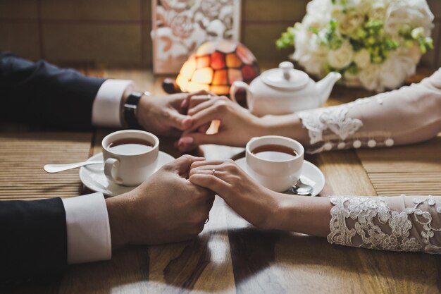 De la mano uno frente al otro con té en el medio 7763