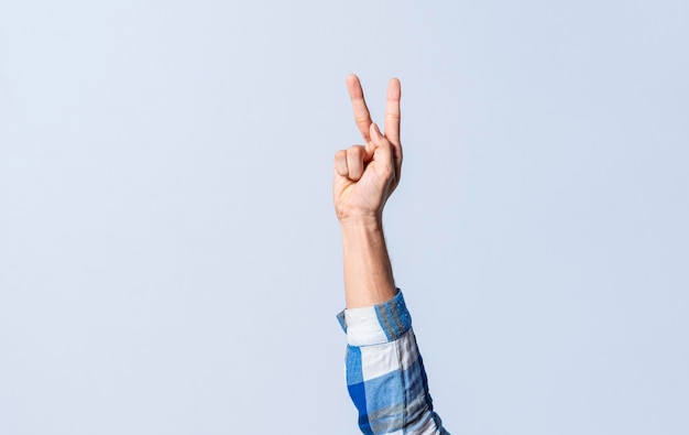 Foto mano gesticulando la letra k en lenguaje de señas sobre un fondo aislado mano del hombre gesticulando la letra k del alfabeto aislado letras del alfabeto en lenguaje de señas